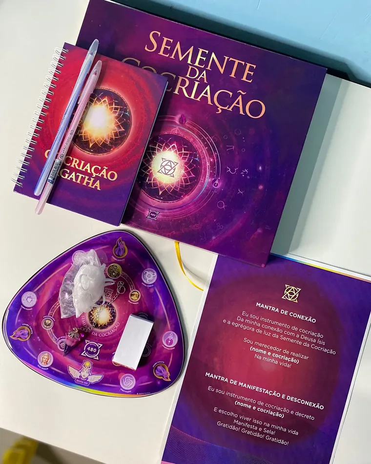 O material da Semente da Cocriação: a mesa, o caderno de cocriação e o cartão com os mantras